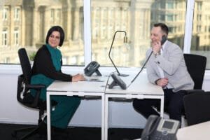 Two people in an office waiting for a call