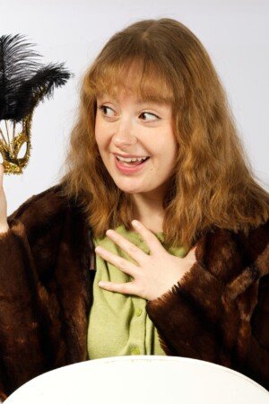 Actor photo shoot lady in a faux fur coat with masquerade mask