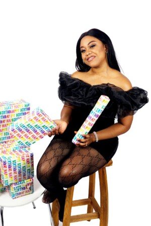 a woman sitting on a stool holding a wrapped present