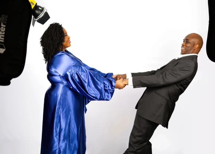 Afro Caribbean couple holding hands in a trust pose and smiling in a photo studio